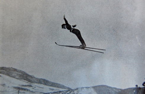 樺太（豊原）で行われた第９回全日本選手権のジャンプ幼年で優勝した安達五郎選手。右下に審判員とおぼしき人影が見え、当時のジャンプの高さがわかる。その安達は、翌年にはオリンピックに出場して８位と大健闘する（スキー年鑑第５号より）